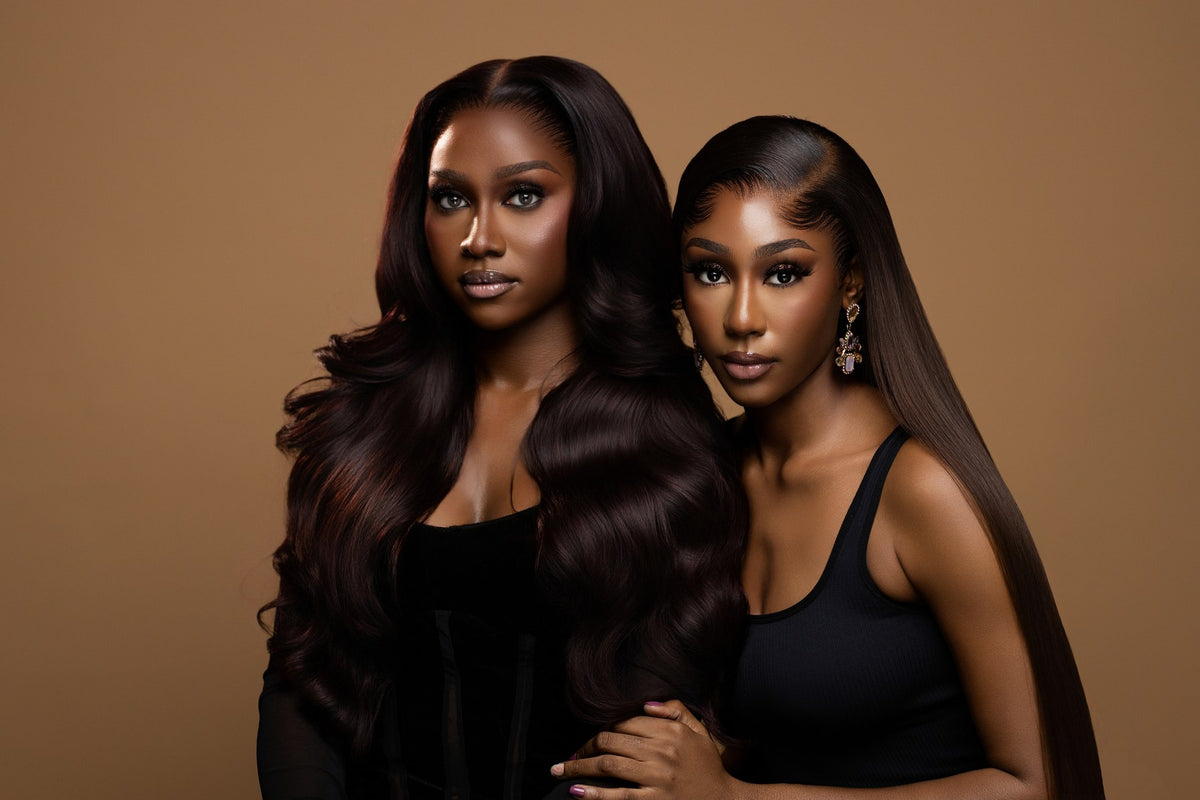 Two models from the campaign stand close together, one with long, dark waves and one with long, straight hair